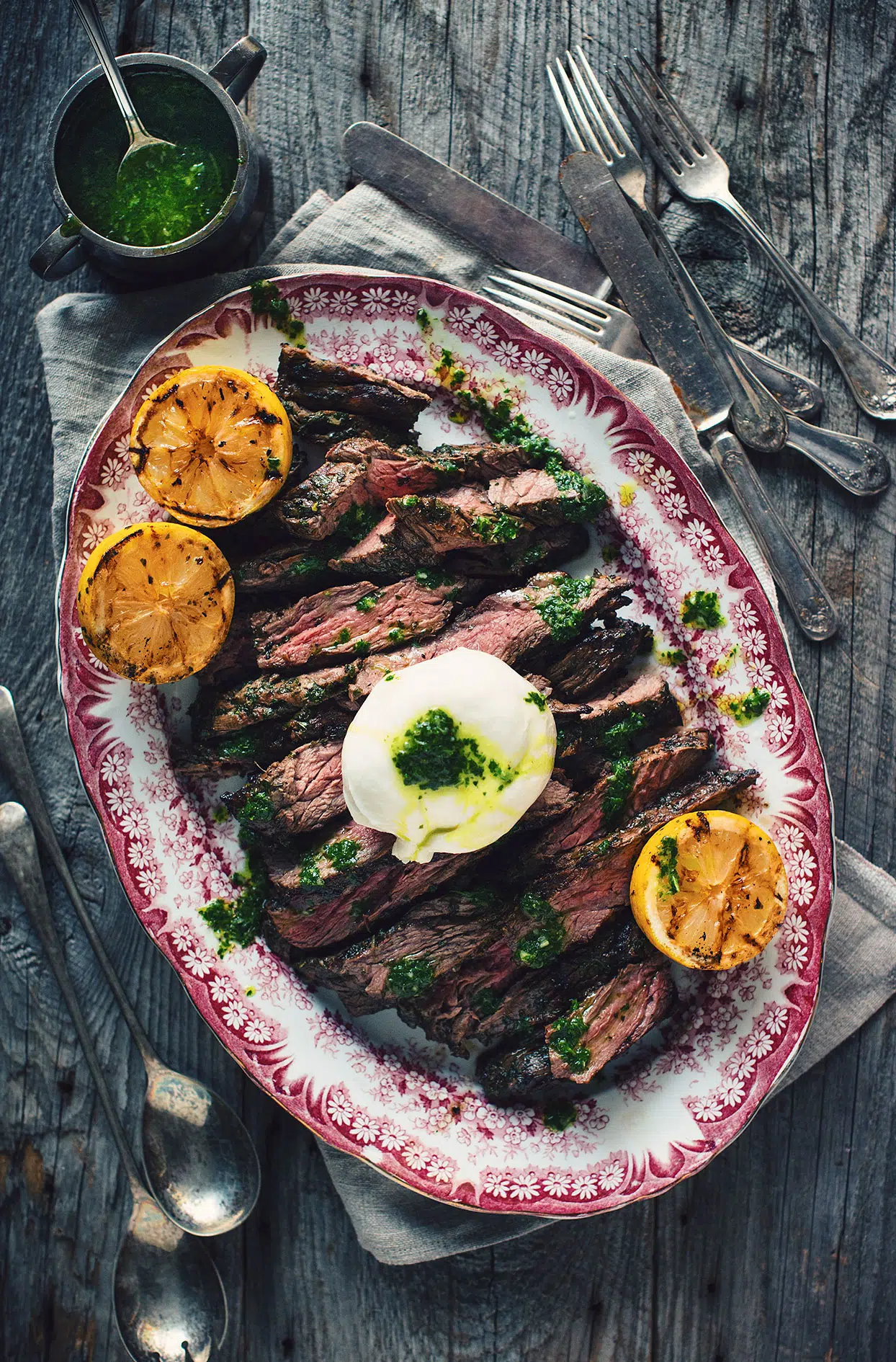 Flank steak with sauce verte and Blanche de Chambly marinade, buratta cheese and grilled lemons
