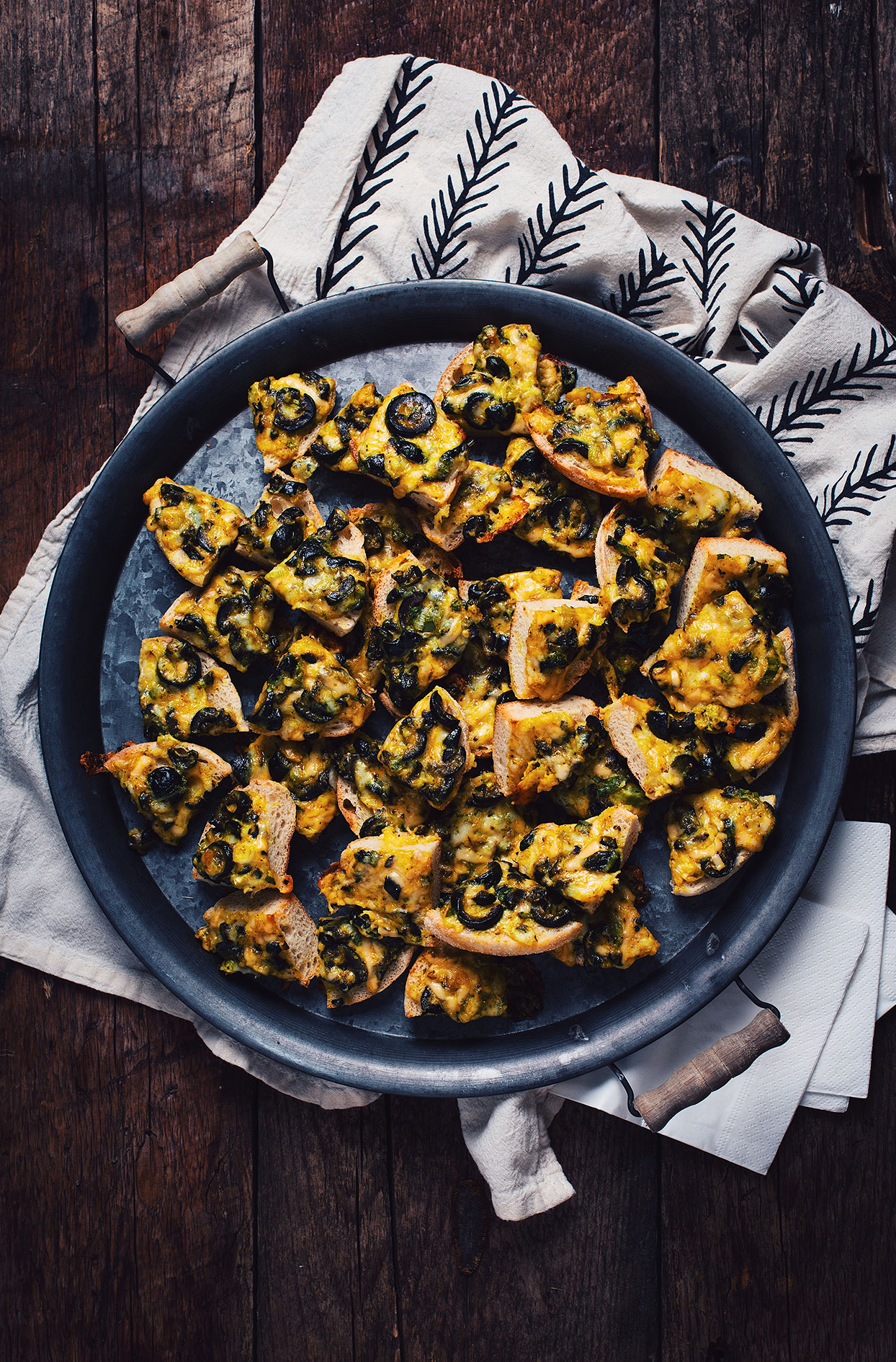 English muffin bites with black olives and cheese