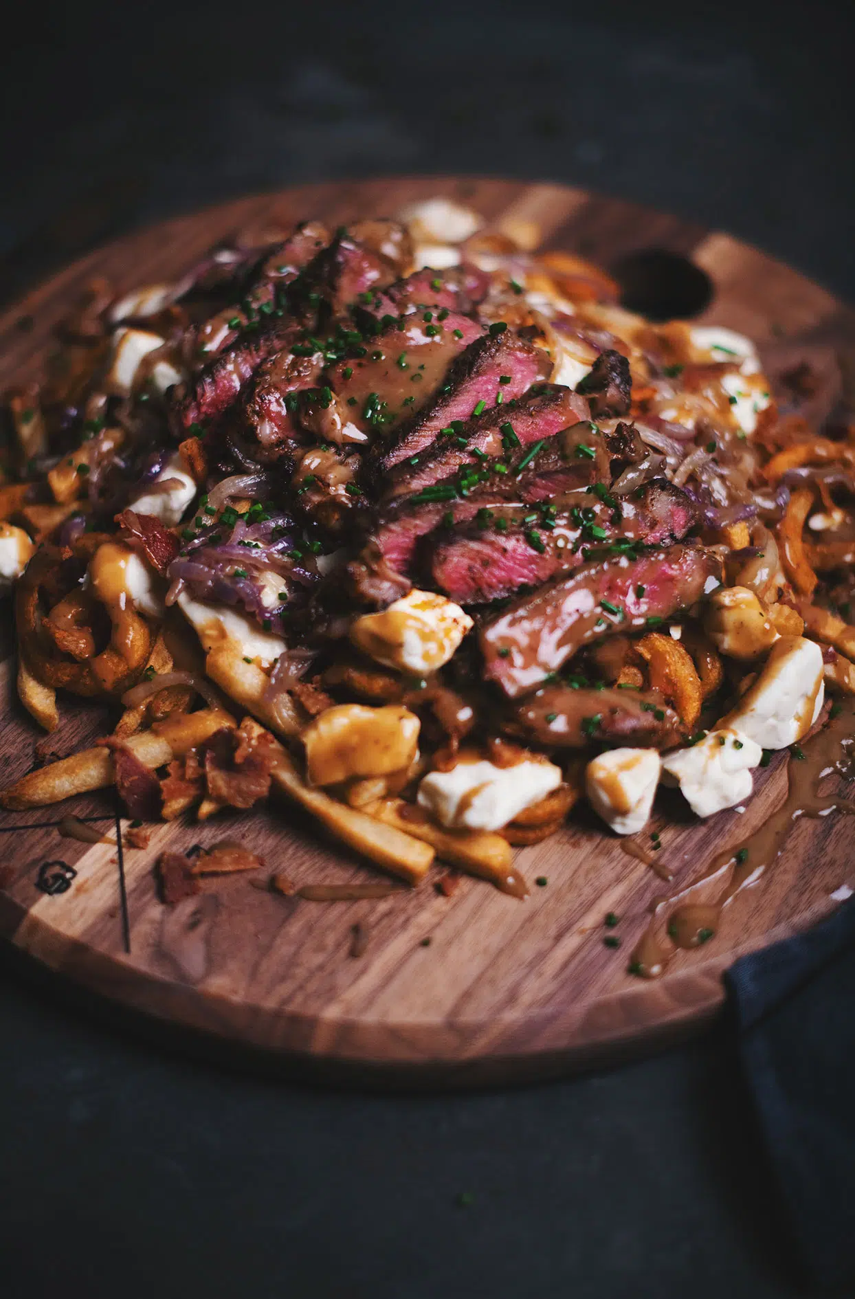 Deluxe poutine with beef ribeye steak, bacon and beer caramelized onions