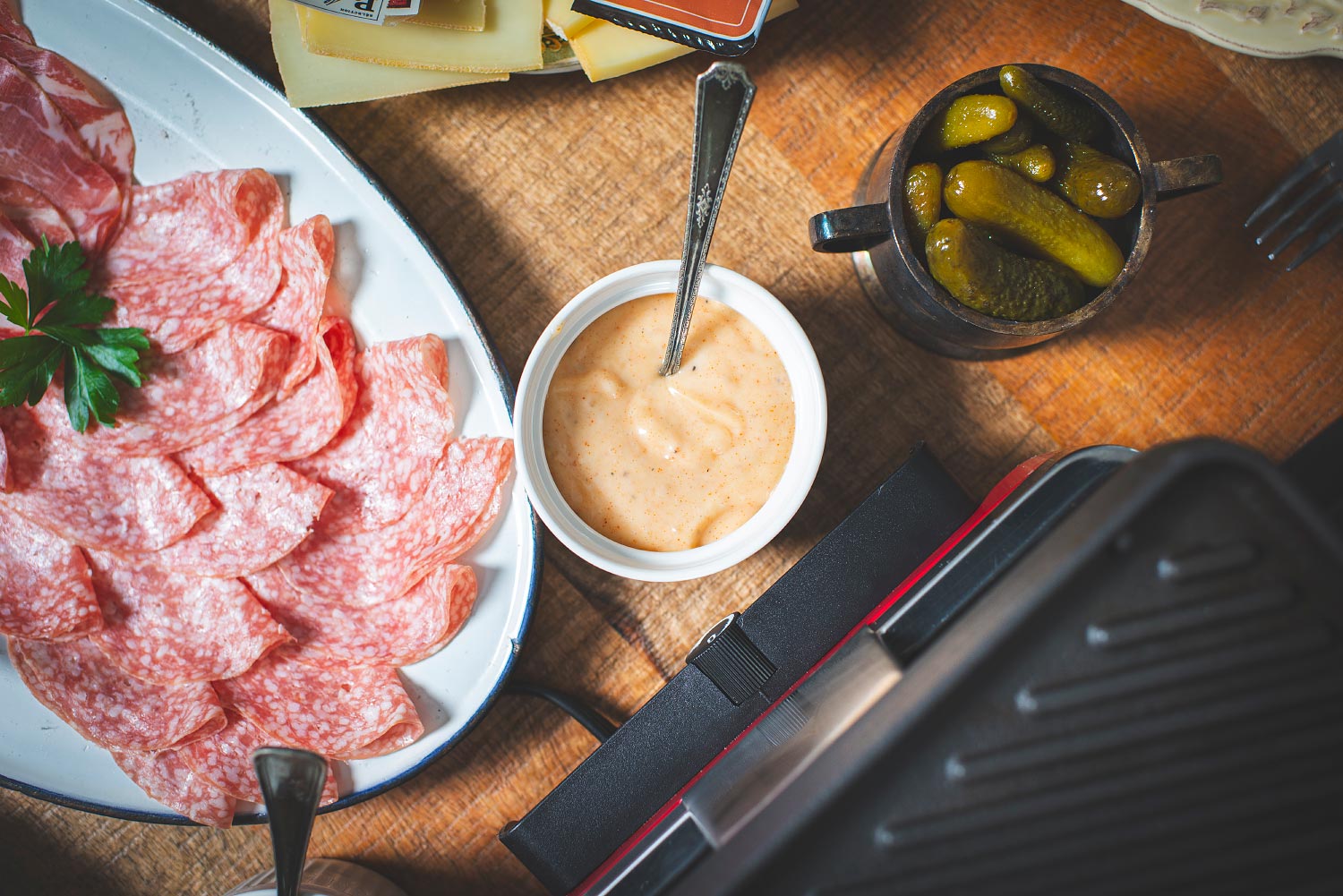 Cornichons et sauce servis avec les charcuteries d'une raclette
