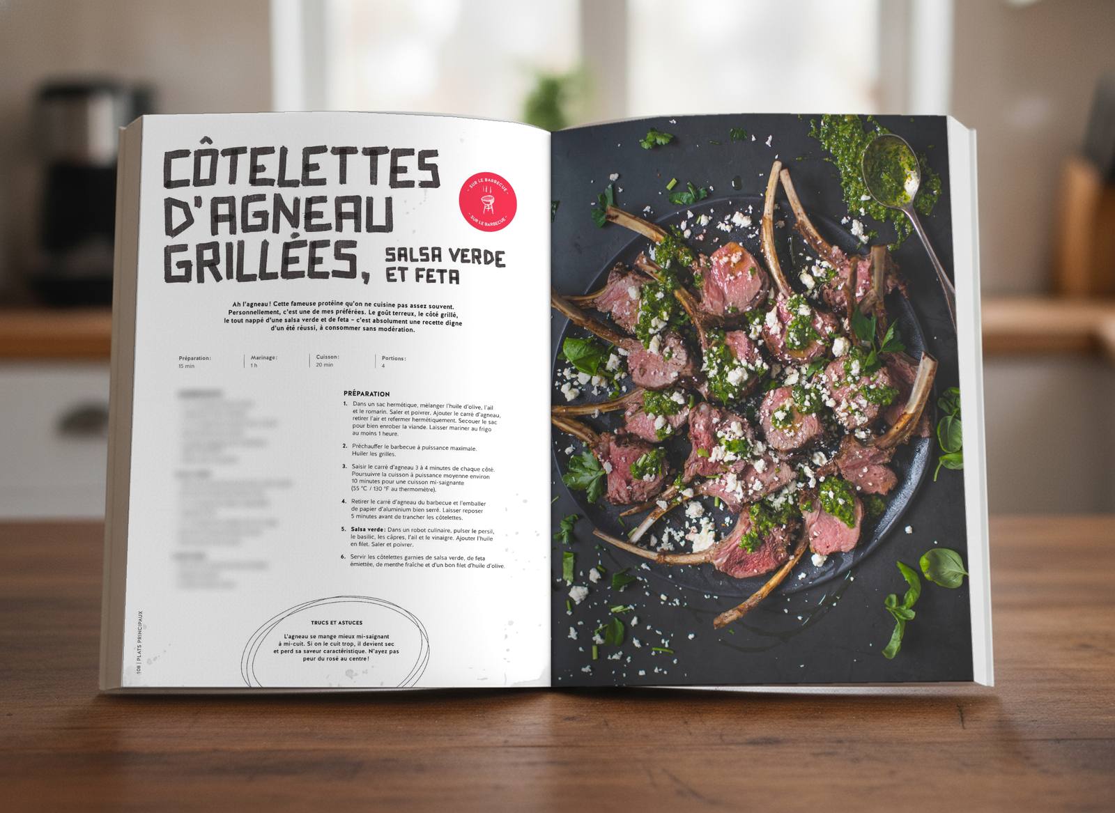 Livre ouvert à la recette des côtelettes d'agneau grillées, ingrédients floutés